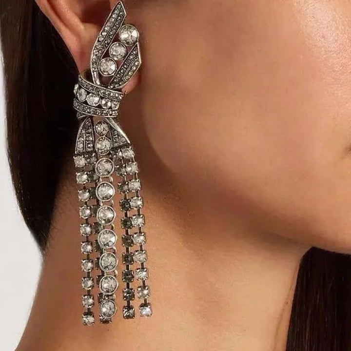 Dazzling women's silver butterfly and bow pendant earrings, featuring sparkling crystals.