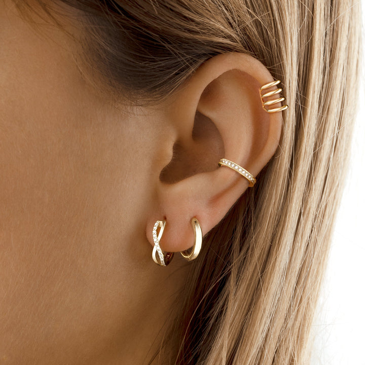 Women's sparkling crossed zirconia hoop earrings, showcasing an elegant design.