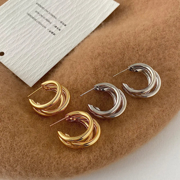 Close-up of elegant stacked hoop earrings, showcasing the intricate gold and silver design. Fashion jewelry.