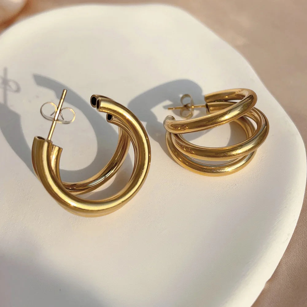 Women's elegant stacked gold and silver hoop earrings, beautifully worn to showcase their fashion style.