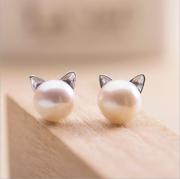 Delicate silver cat ear earrings for women, featuring lustrous natural pearls. Perfect elegant jewelry accessory.