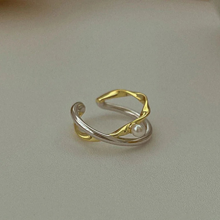 Stylish women's sterling silver crossed ring with a classic pearl, a versatile and elegant accessory.