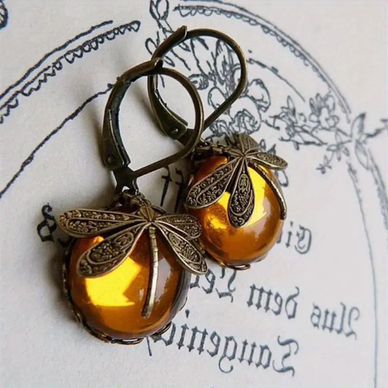 Elegant women's sterling silver dragonfly drop earrings with radiant moonstone.