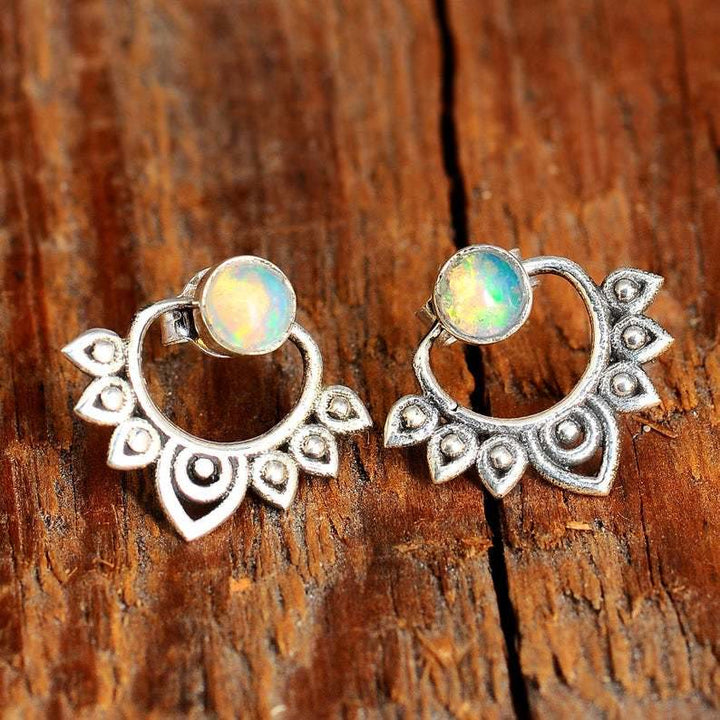 Close-up of delicate women's sterling silver lotus earrings featuring vibrant natural opal inlays.