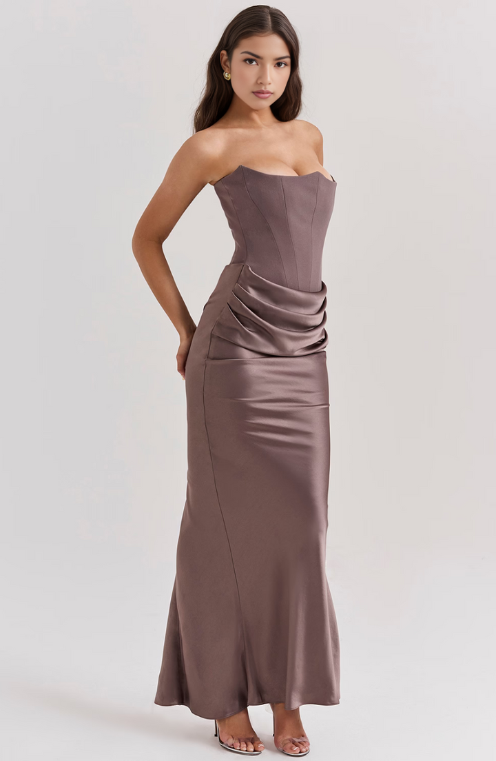 Flowing strapless maxi wedding guest dress with a flattering corset top, perfect for elegant affairs.