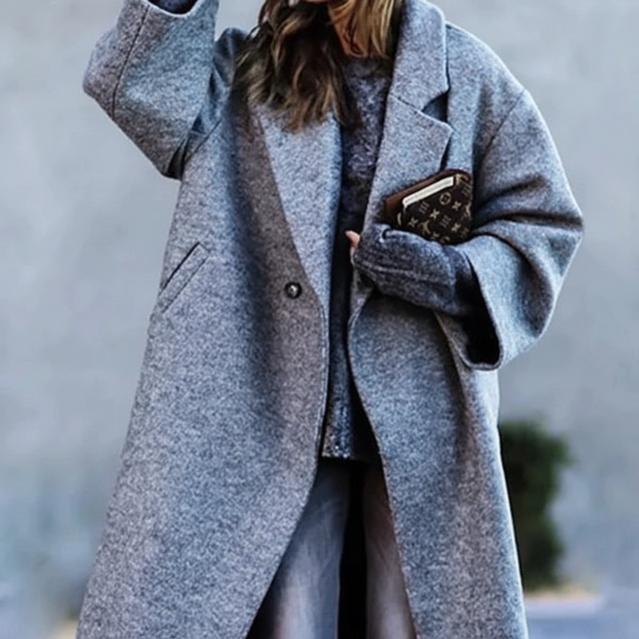 Side view of a long women's tailored wool winter coat, emphasizing its sleek silhouette and quality.