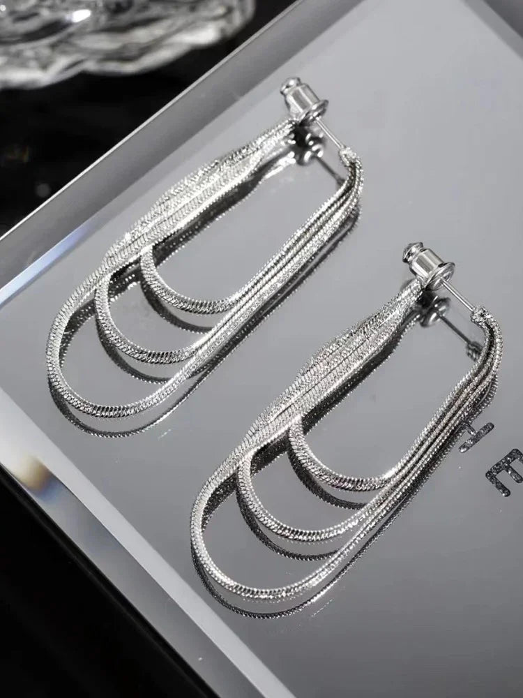 Fashionable women's three-layer drop earrings with elegant chain detail. Versatile gold or silver jewelry.