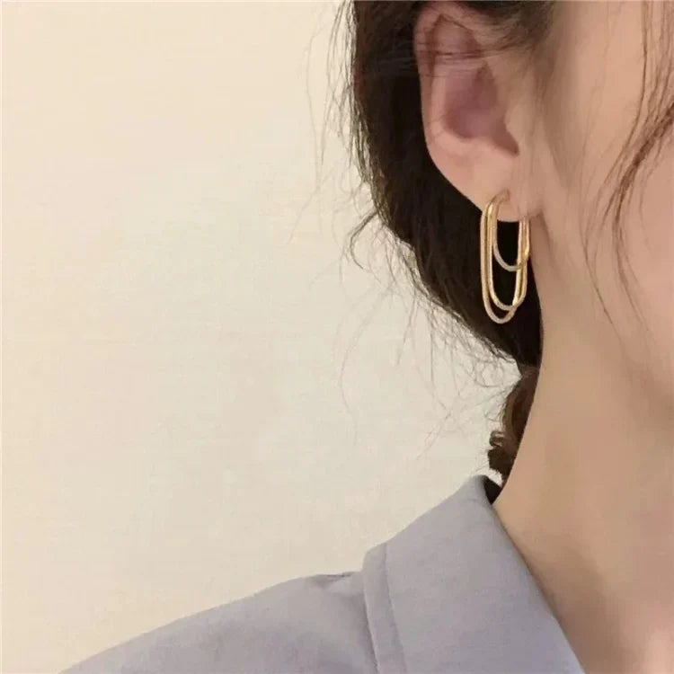 Women's three-layer chain drop earrings. Modern layered gold or silver jewelry for a sophisticated look.