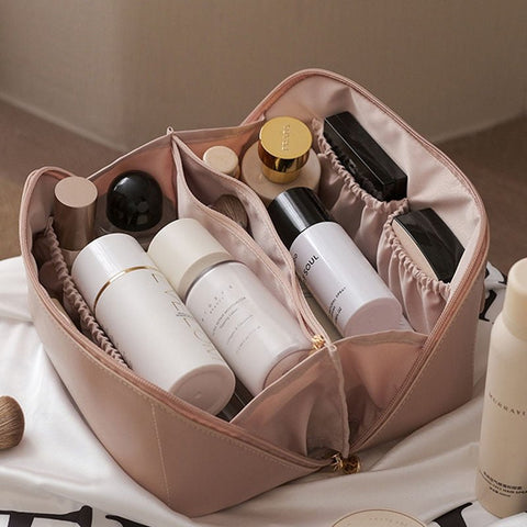 Women's elegant pink makeup organizer with compartments, ideal for travel and beauty essentials.