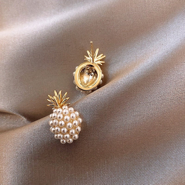 Stylish women's pearl drop earrings with a golden pineapple design, adding a touch of tropical elegance to any look.