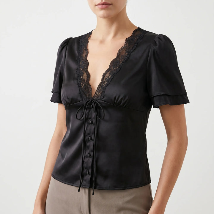 Chic women's V-neck blouse featuring elegant lace trim & short sleeves. Versatile for casual or dressy day to night wear.