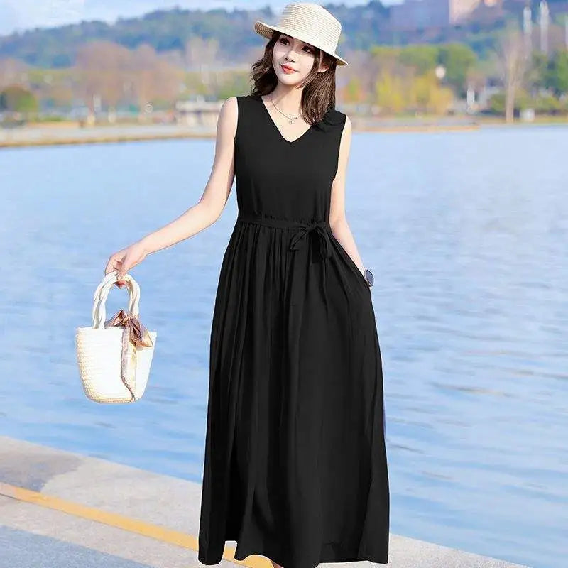 Flowy sleeveless maxi dress for women, V-neck, tie waist & pockets. Ideal for casual summer days.