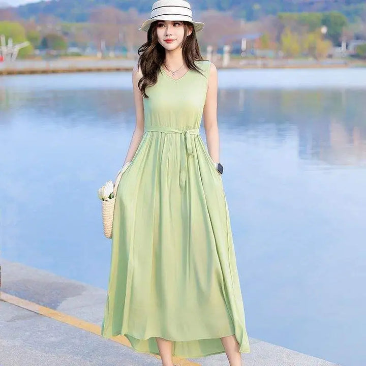 Woman enjoying a vacation, wearing a chic V-neck tie waist sleeveless maxi dress with pockets.
