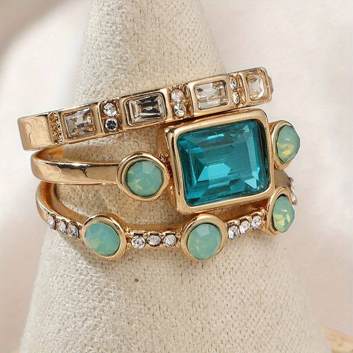 Close-up of a vintage gold-plated ring featuring a radiant blue crystal. Perfect elegant women's jewelry.