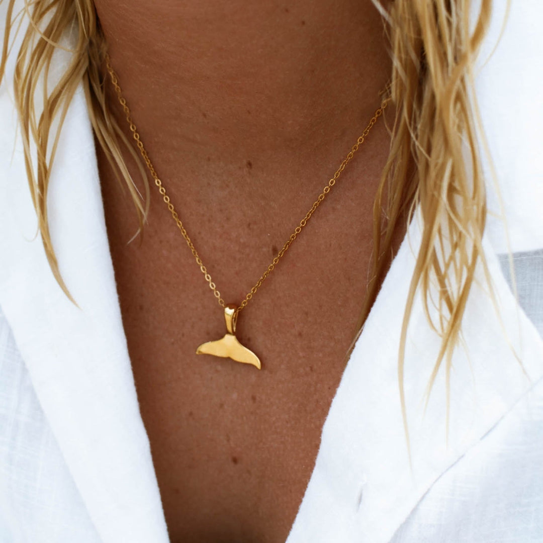 Elegant women's whale tail pendant necklace, perfect ocean-inspired jewelry. Available in silver or gold finishes.