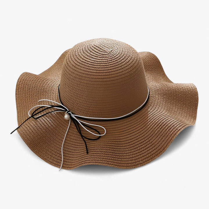 Elegant women's wide brim sun hat with a large bow, perfect for summer beach fashion and UV protection