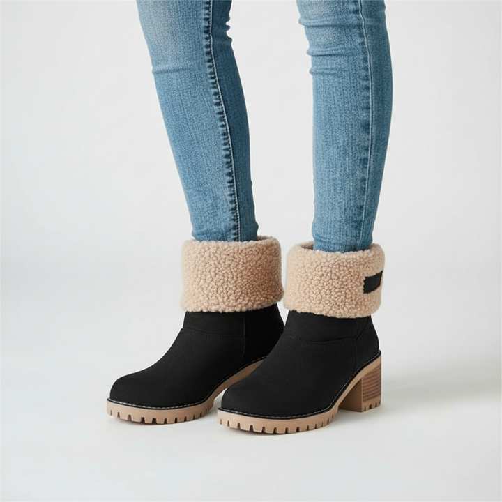 Pair of black women's fashion boots, faux fur lined for warmth, perfect for winter outfits