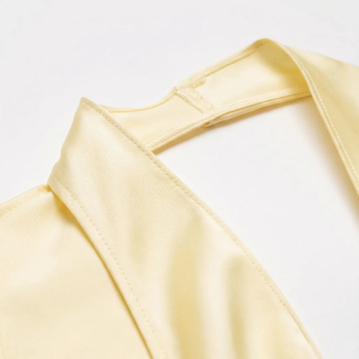 Modern yellow draped halter top for women with a stylish asymmetrical hem. Elegant sleeveless design, ideal for summer evenings.