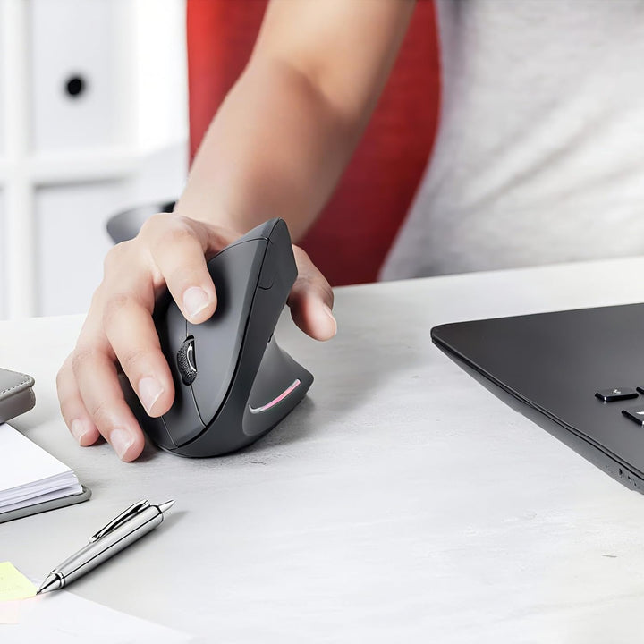 Lifestyle image of the Elvion rechargeable vertical mouse in a modern office setup aiding wrist comfort.