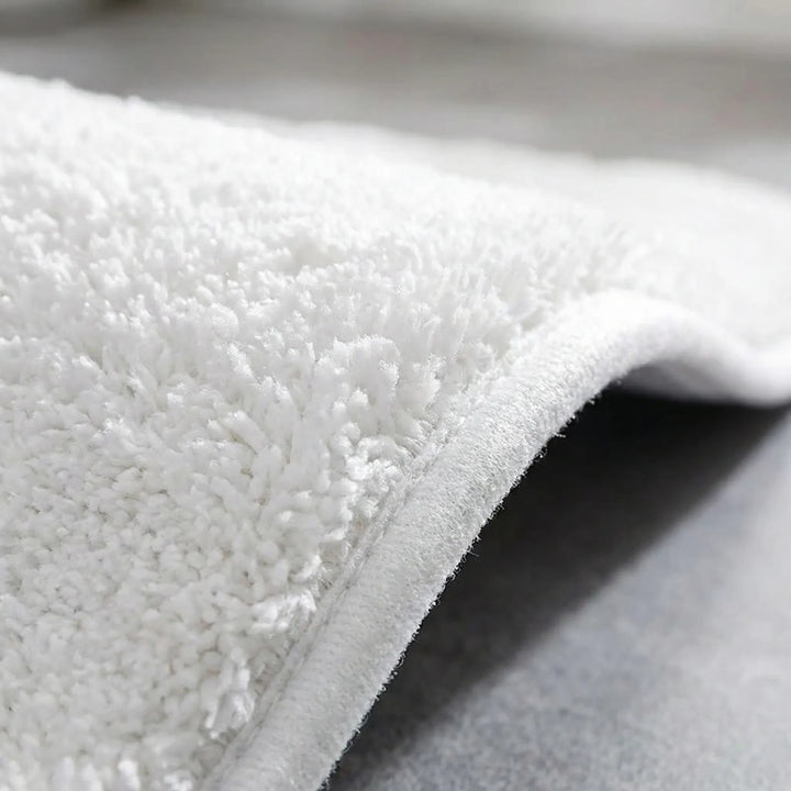 Plush absorbent bath mat with non-slip backing. Machine washable for easy home comfort.