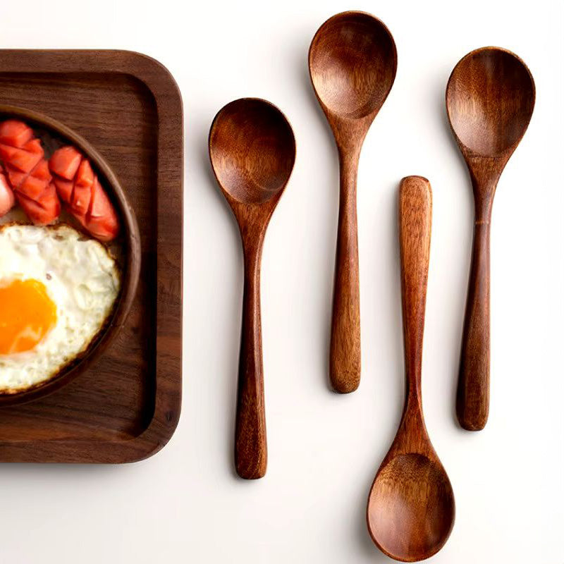 Close-up of a natural wooden serving spoon, part of an eco-friendly farmhouse kitchen utensil set.