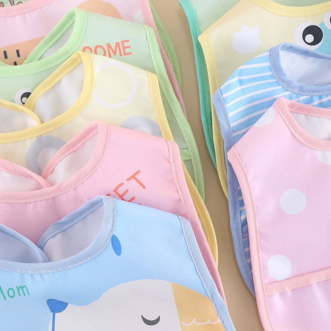 High-angle shot of five waterproof adjustable baby bibs laid out, highlighting their bright colors