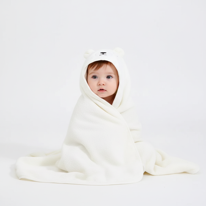 Newborn drying off with a gentle FluffyTowel hooded bath towel, perfect for sensitive baby skin