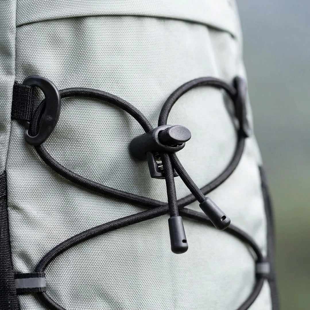 Close-up of a water-repellent green hiking daypack with multiple compartments for outdoor gear.
