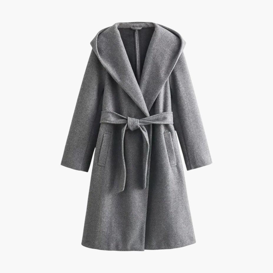 Full view of women's hooded belted trenchcoat in a casual outdoor setting. Stylish women's outerwear.