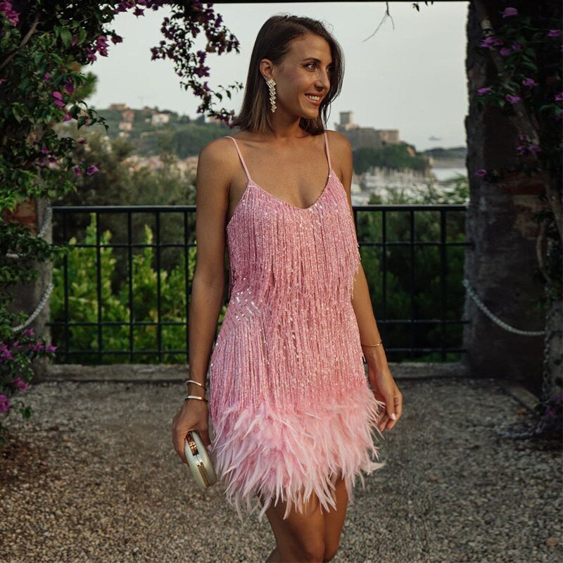 Sparkling women's sequin cocktail dress, sleeveless, featuring an elegant feather trim. Ideal for evening parties.