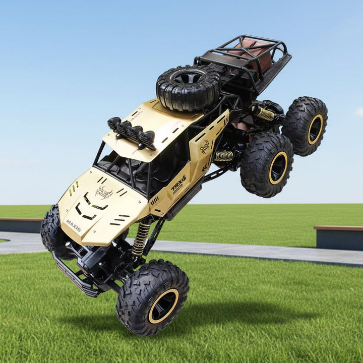 Gold & black 6x6 RC monster truck, ready for all-terrain off-road adventure. Durable remote control toy vehicle.
