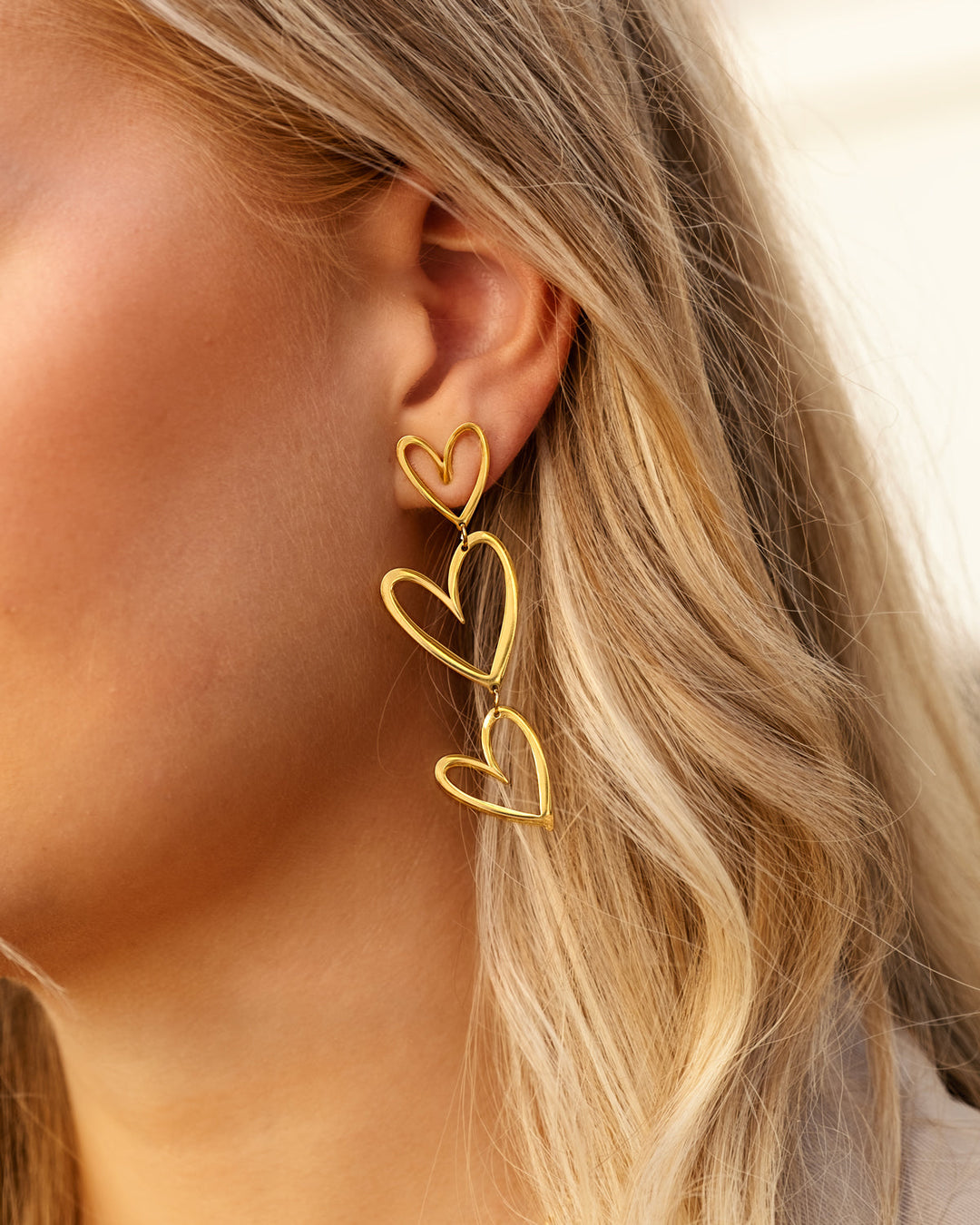 Women's sterling silver triple heart pendant earrings with a beautiful gold plated finish.