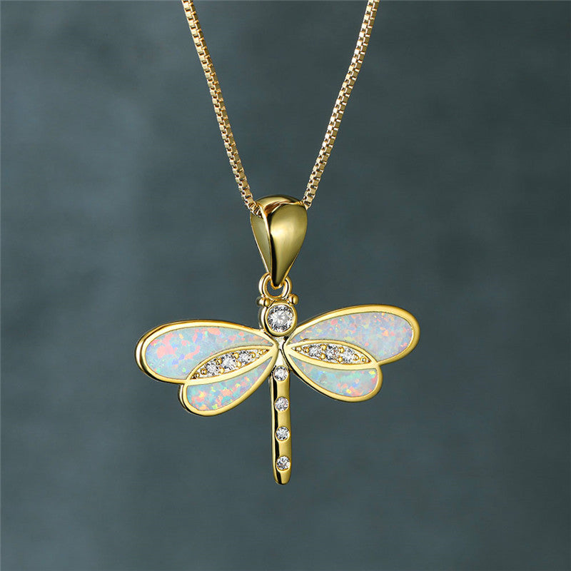 Close-up of a delicate golden dragonfly opal necklace, perfect elegant nature-inspired women's jewelry.
