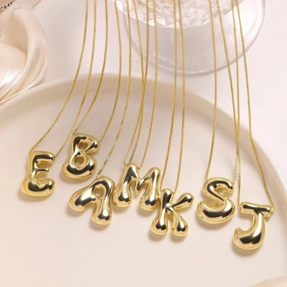 Woman wearing a stylish golden initial pendant necklace, showcasing personalized letter jewelry.