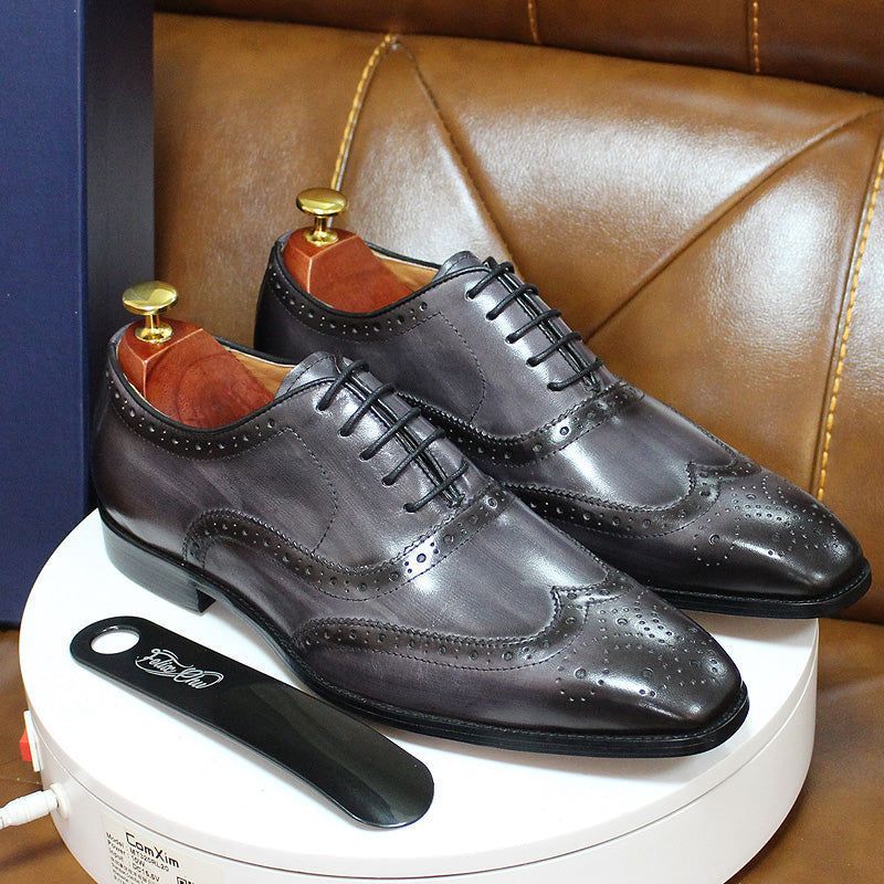 Classic brown leather men's wingtip oxford shoes. Handcrafted formal dress footwear with intricate brogue detailing.