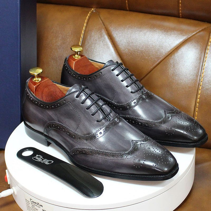 Classic brown leather men's wingtip oxford shoes. Handcrafted formal dress footwear with intricate brogue detailing.