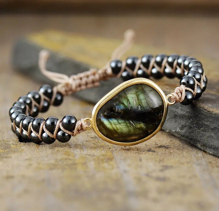 Stylish unisex natural stone braided cuff bracelet on a wrist, featuring dark onyx beads. Adjustable & comfortable.