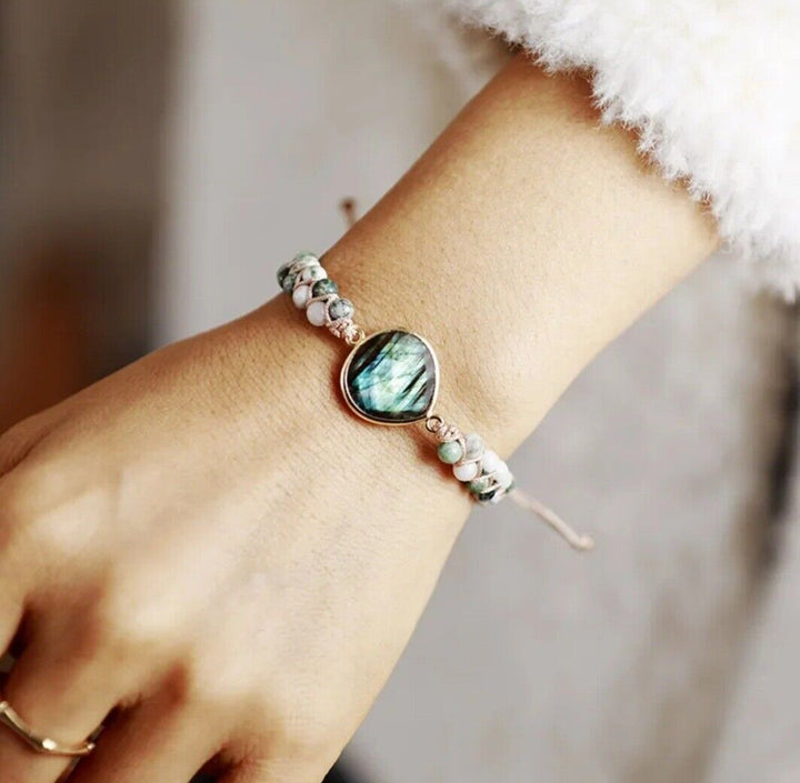 Close-up of a handmade natural stone braided cuff bracelet, showcasing intricate weave, onyx, & hematite beads.