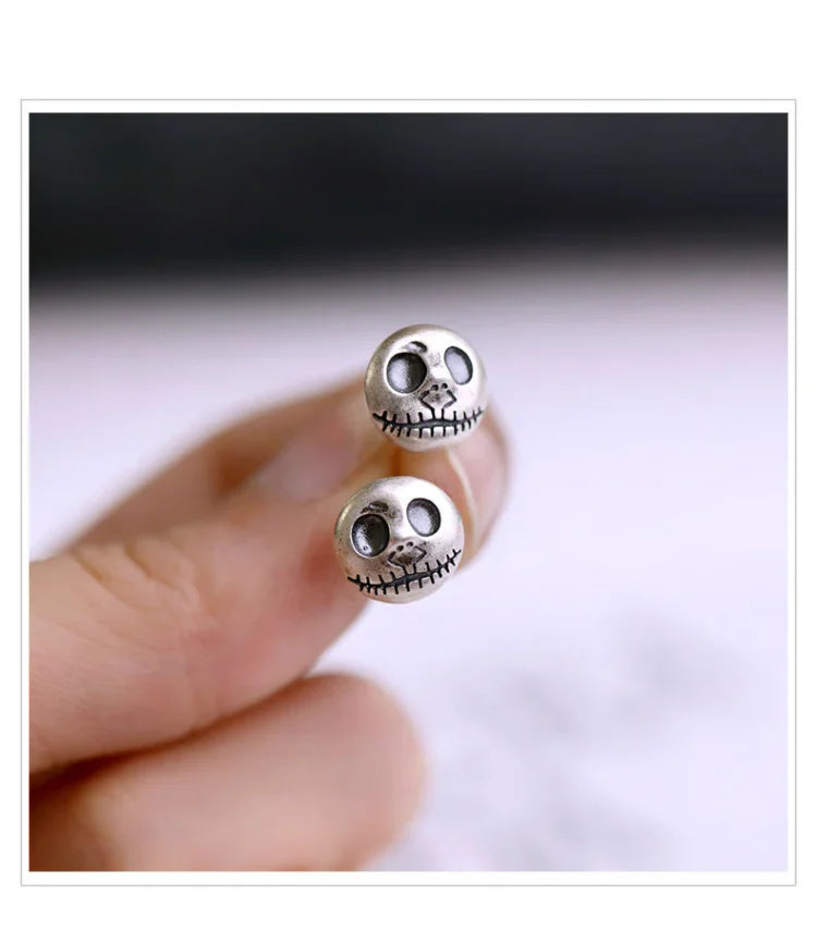 Women's handmade pumpkin skull earrings, detailed unique jewelry for Halloween or a bold fashion statement.