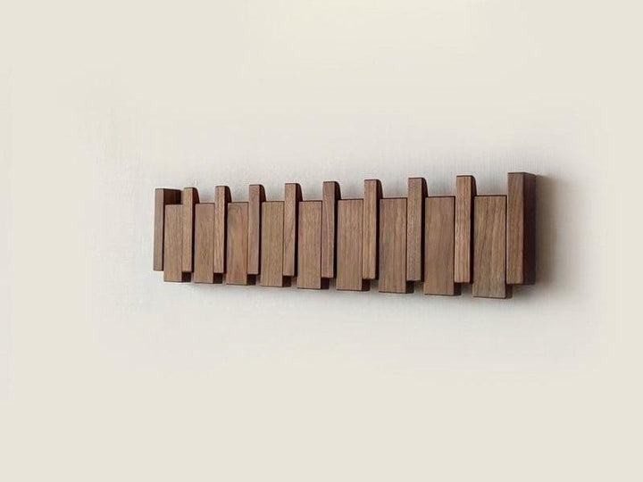 Modern wooden coat rack with innovative folding hooks. Wall-mounted entryway storage for decluttering hallways.