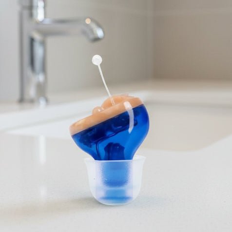 Invisible in-ear hearing aid, discreetly improving sound clarity for mild to moderate hearing loss.