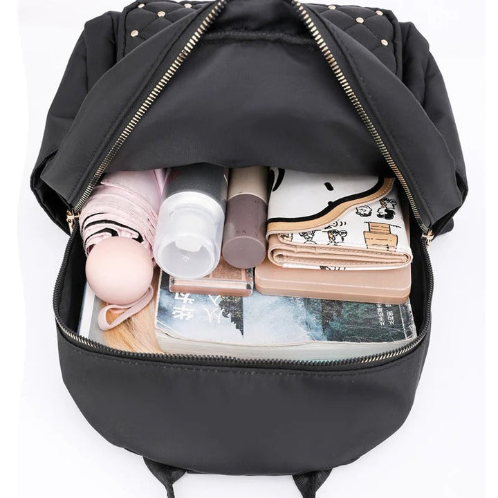 Stylish black water-resistant nylon backpack for women, open to show spacious interior for travel.