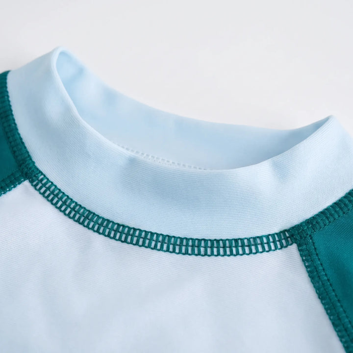 Long sleeve rash guard top for kids, a crucial piece of sun protection swimwear for active children.