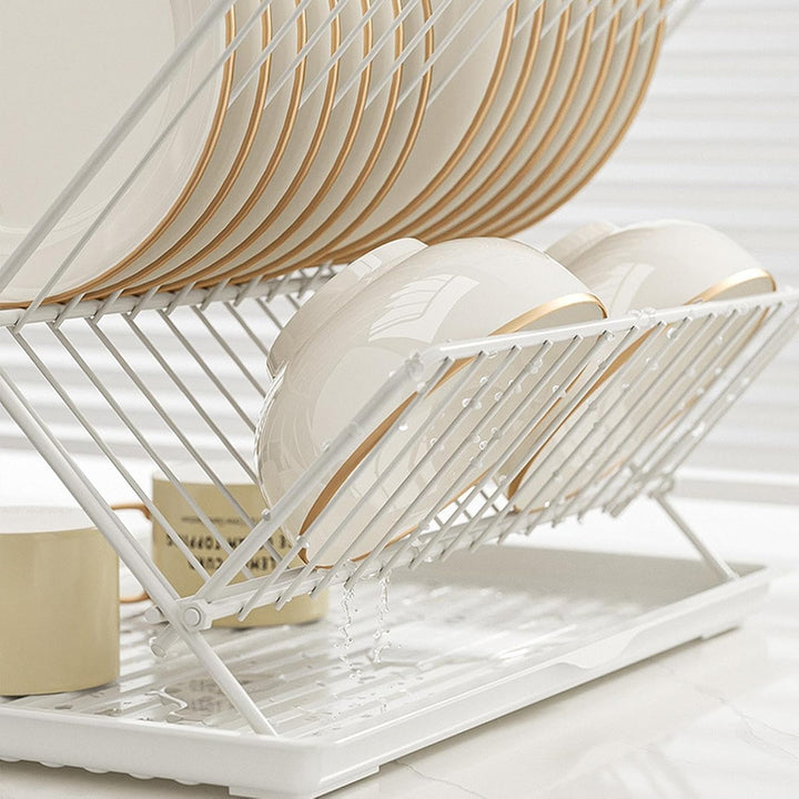 Compact 2-tier countertop dish drainer, foldable for easy storage, includes a convenient detachable tray.