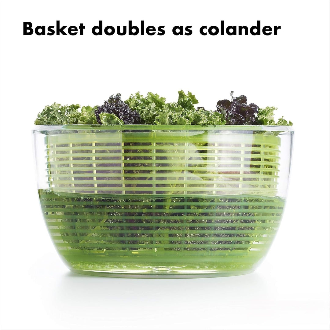 Freshly washed lettuce being dried in a large transparent salad spinner, a key food preparation item.