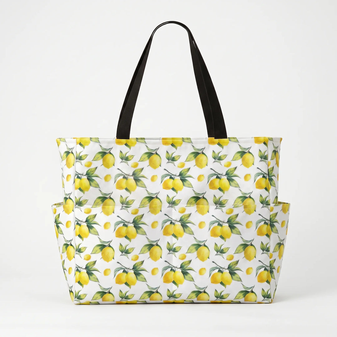 Woman carrying a stylish large tropical lemon print beach tote bag, perfect for summer outfits.