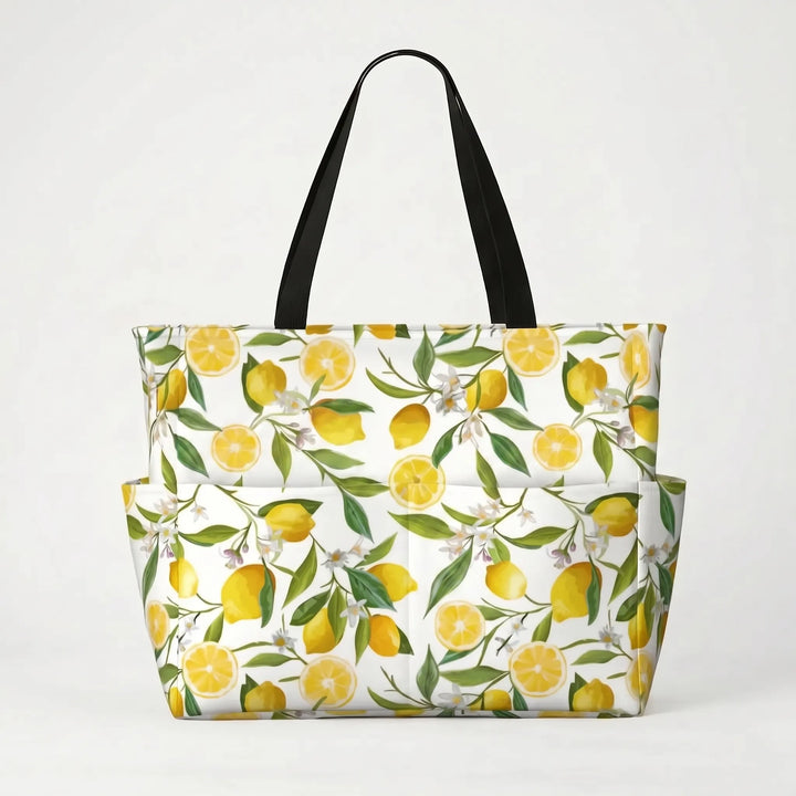 Tropical lemon print large beach tote bag on sand, ready for a relaxing vacation day by the ocean.