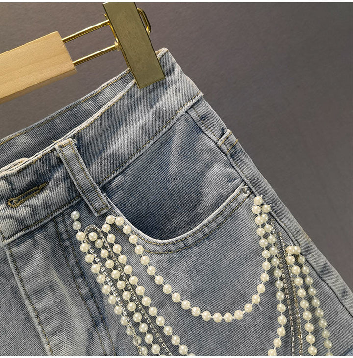 Chic women's light blue shorts featuring elegant pearl and tassel details, ideal for summer fashion.