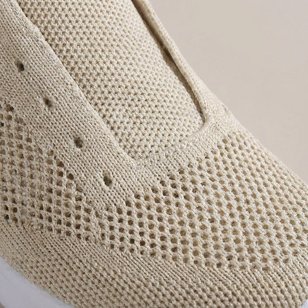 Close-up of a women's lightweight sneaker, highlighting its breathable knit upper texture.