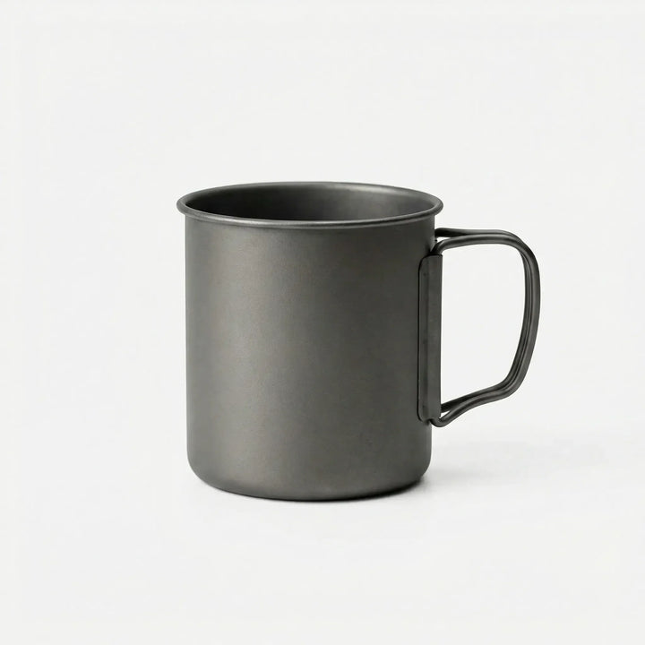 Durable titanium outdoor cup with compact foldable handle, ideal for travel, bushcraft, and survival kits.